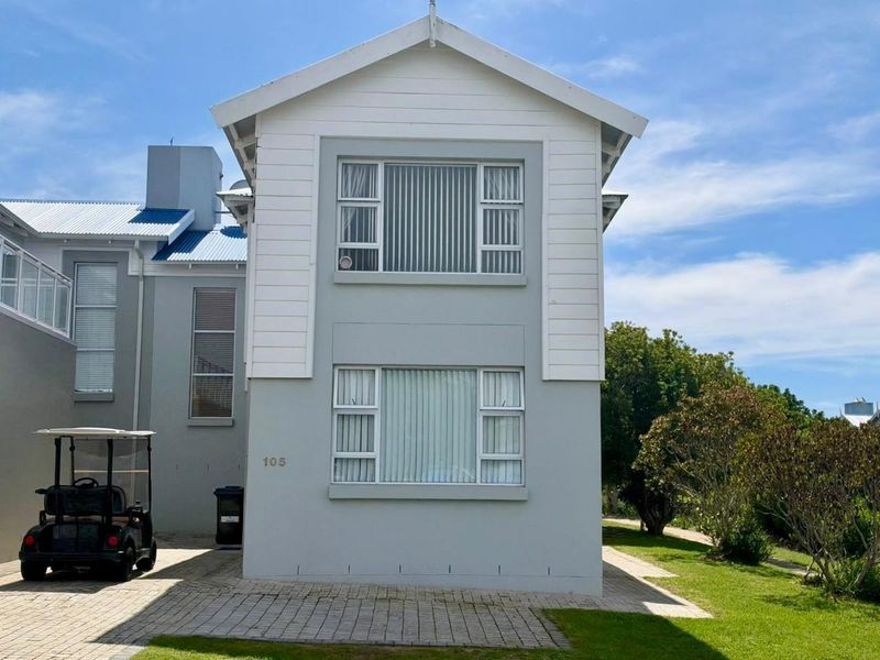 Front elevation of a two-story residential property featuring a paved driveway, light grey exterior finish, and white window frames.