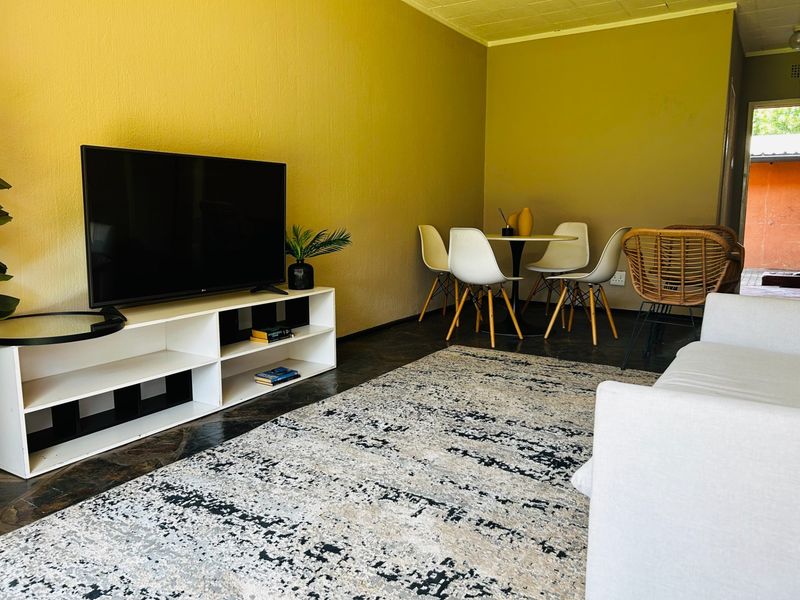A living room area featuring tiled flooring and neutral wall finishes, providing a functional space for relaxation and dining.