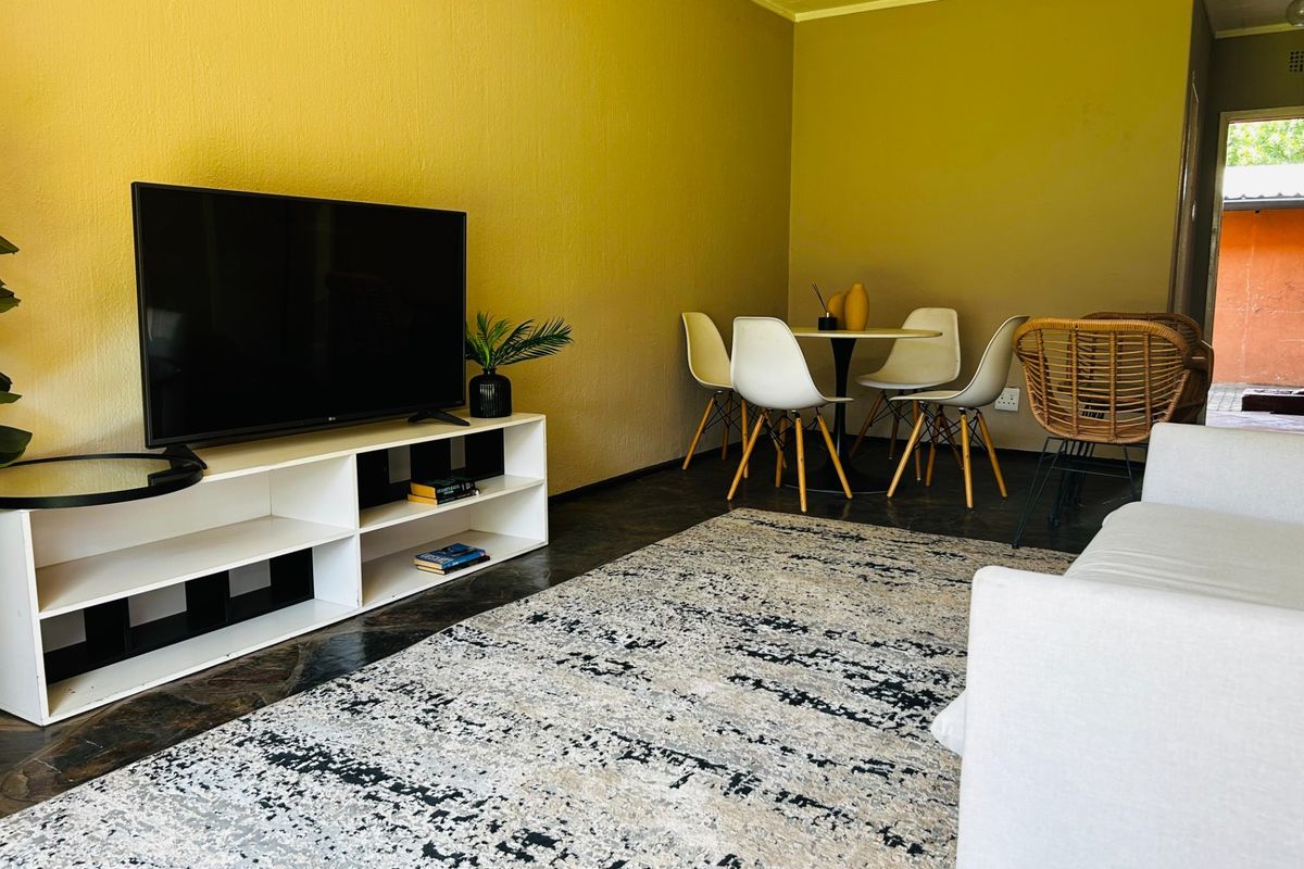 A living room area featuring tiled flooring and neutral wall finishes, providing a functional space for relaxation and dining.