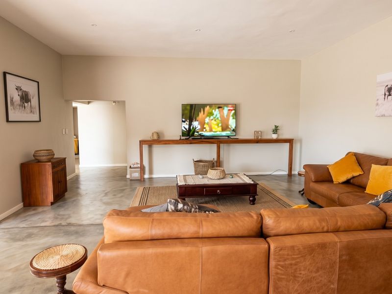 Spacious living room featuring polished concrete flooring and neutral wall tones, offering a clean and modern aesthetic.