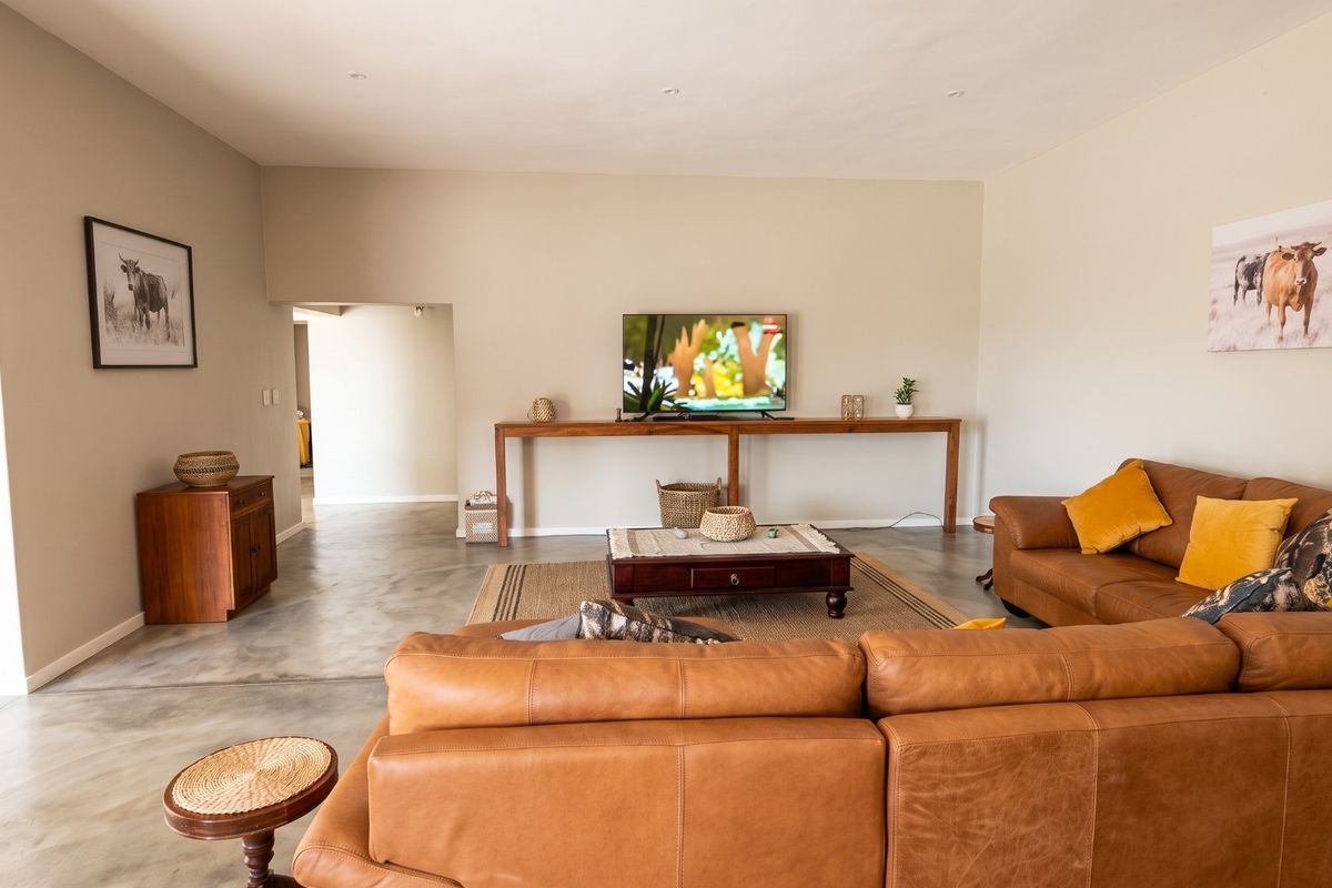 Spacious living room featuring polished concrete flooring and neutral wall tones, offering a clean and modern aesthetic.