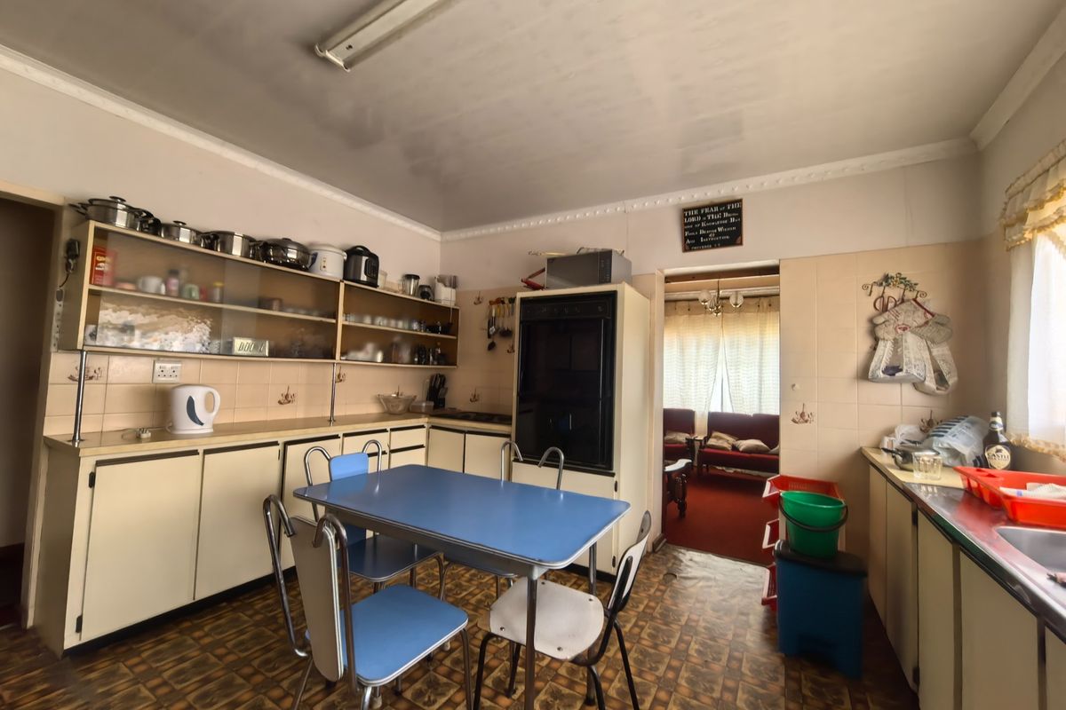 A dated kitchen featuring original built-in cabinetry, a built-in oven, and tiled backsplash, offering significant potential for modernization and renovation.