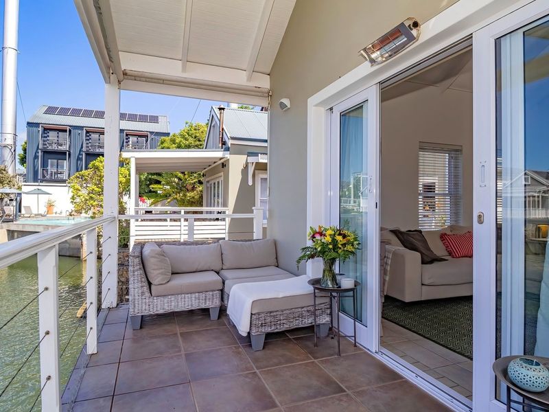 A covered balcony featuring tiled flooring, a protective railing, and sliding glass doors that provide seamless access to the interior living space.