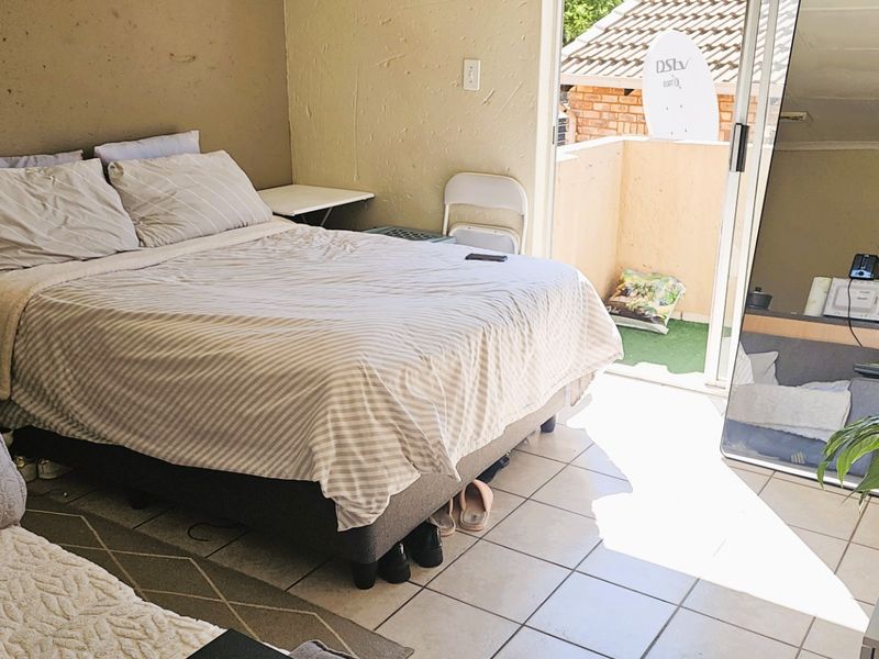 Bedroom featuring tiled flooring and direct access to a private balcony through a sliding glass door.