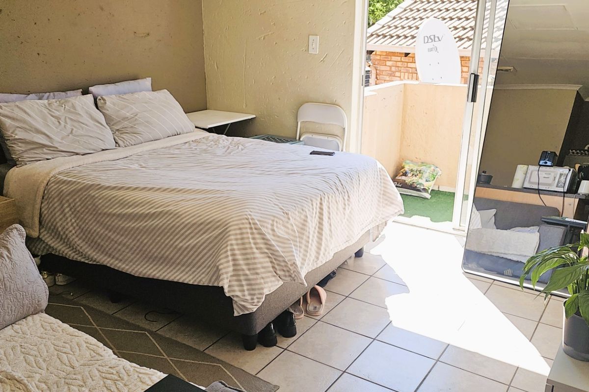 Bedroom featuring tiled flooring and direct access to a private balcony through a sliding glass door.