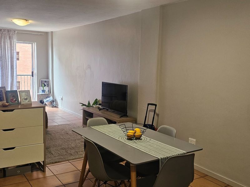 Open plan living and dining area featuring tiled flooring and a sliding glass door leading to a balcony.