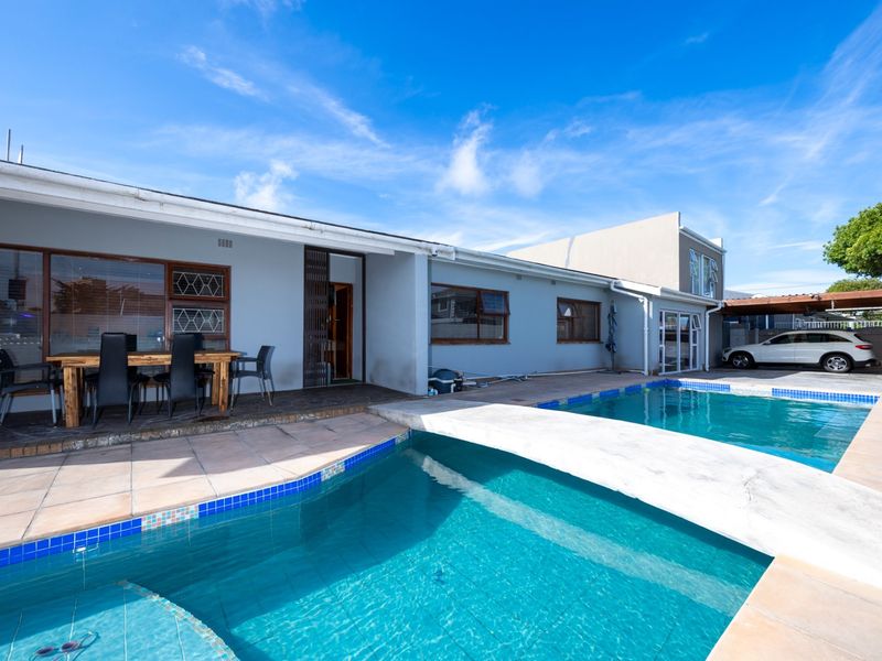 Outdoor entertainment area featuring a swimming pool, tiled patio space, and direct access to the home via sliding doors.