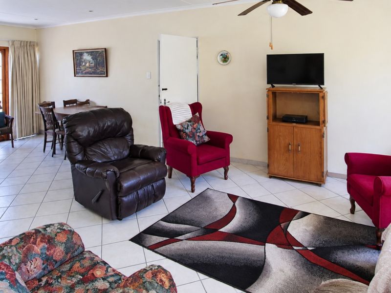 Open plan living and dining area featuring tiled flooring, recessed lighting, and a ceiling fan with access to an outdoor space via sliding doors.