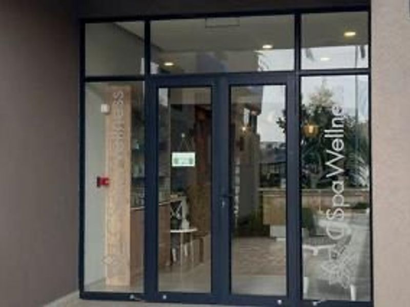 Modern glass and aluminium entrance doors providing access to the building's spa and wellness facility.