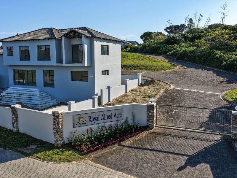 Aerial view of a modern two-story residential property featuring a paved driveway, secure gated entrance, and perimeter walling within Royal Alfred Acre.