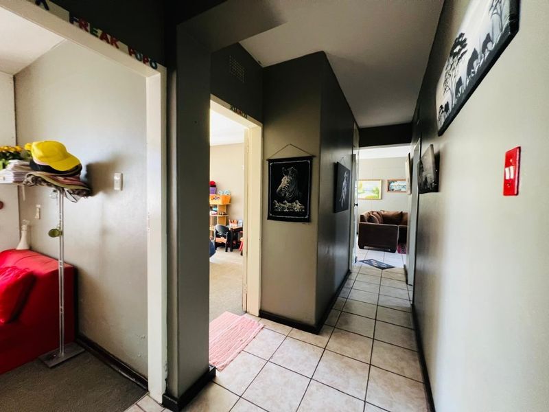 A functional hallway featuring tiled flooring and access to multiple rooms within the apartment.
