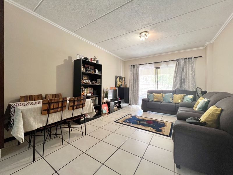 Open plan living and dining area featuring tiled flooring and a sliding glass door providing access to the exterior.
