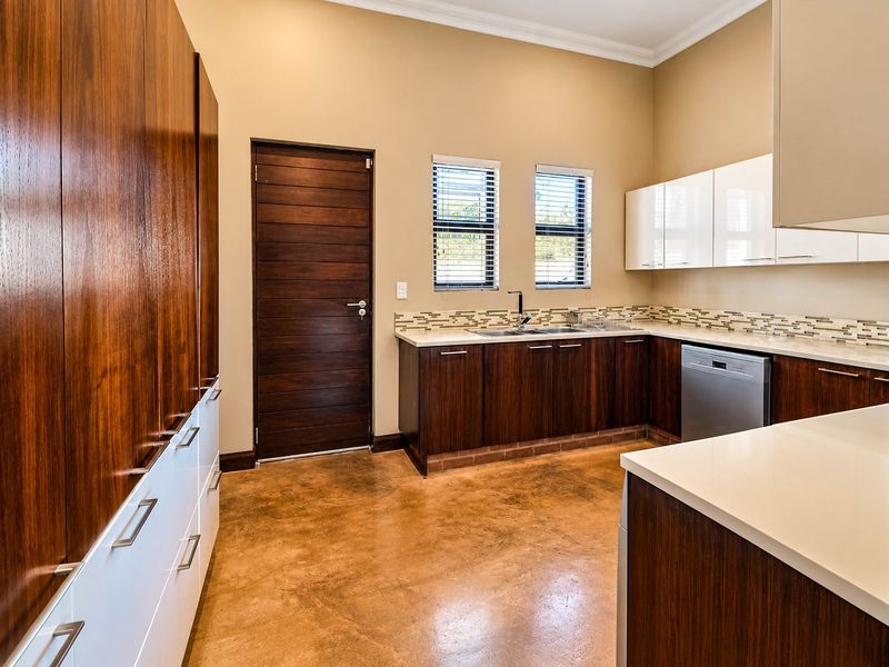 Modern kitchen featuring polished concrete floors, dark wood and white cabinetry, stone countertops, and a mosaic tile backsplash.
