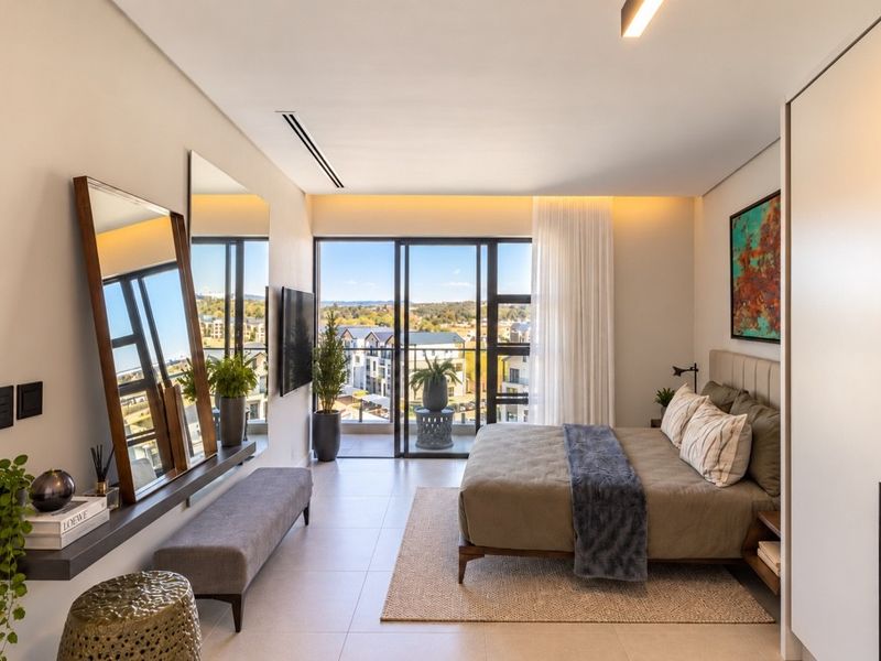 Modern penthouse bedroom featuring sleek tiled floors, built-in cabinetry, and large sliding glass doors opening to a private balcony with expansive views.