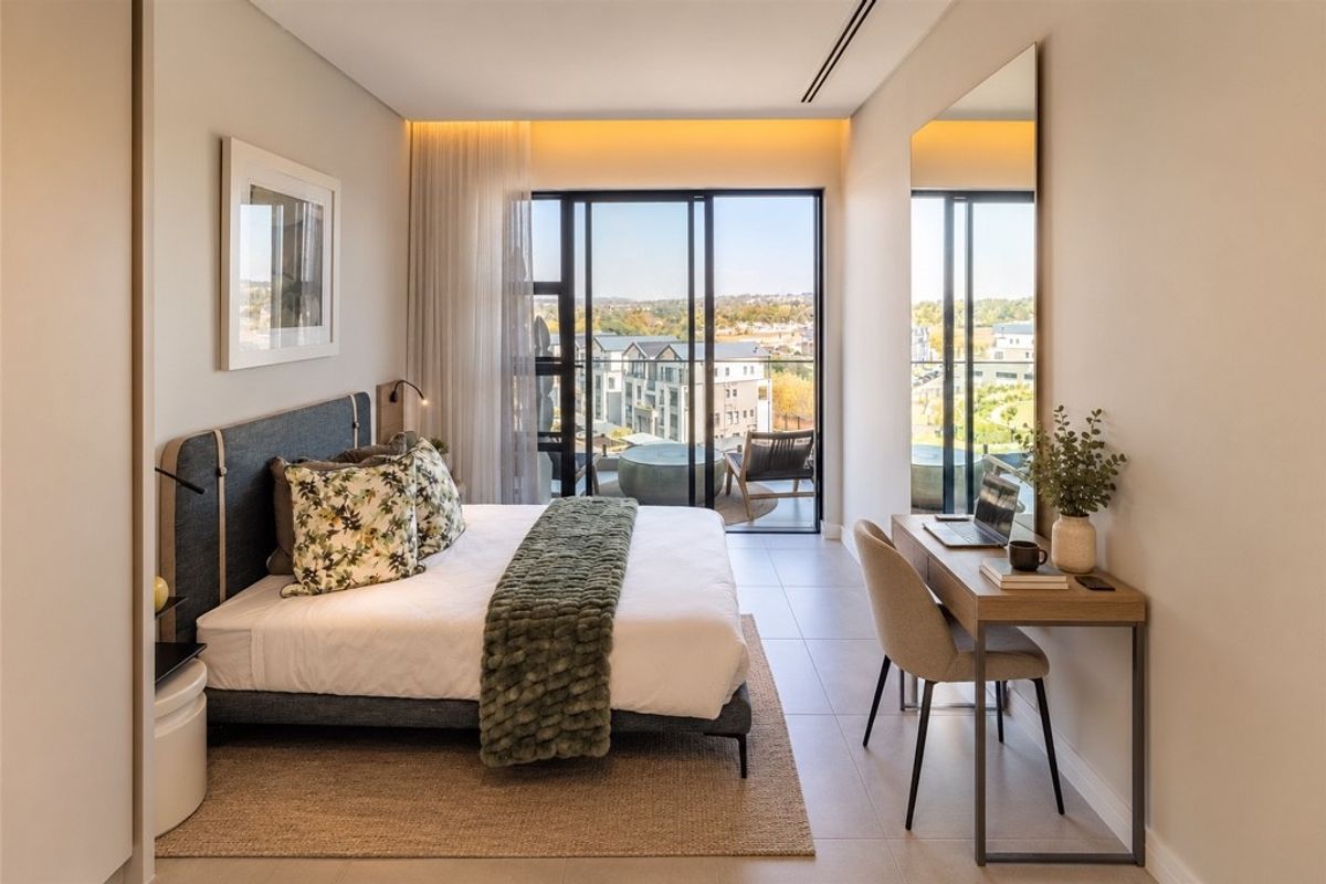 Modern penthouse bedroom featuring tiled floors, recessed lighting, and large sliding glass doors opening onto a private balcony with scenic views.