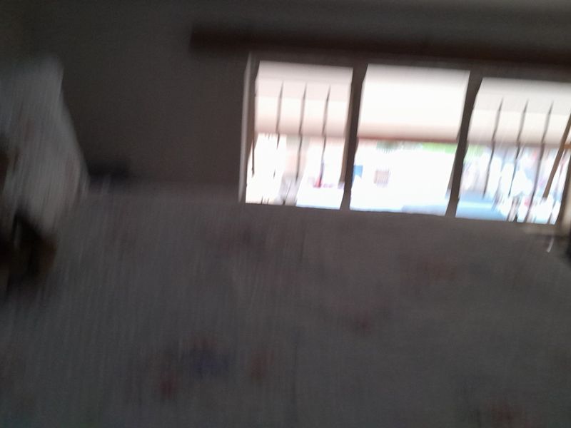 A bedroom featuring a window with security bars, captured in a low-quality, blurry image.