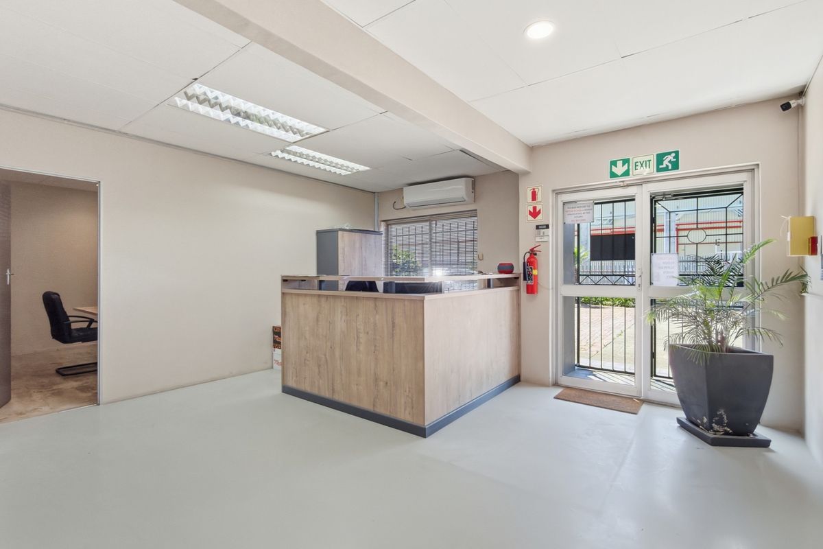 A clean industrial reception area featuring a built-in service desk, security gate, and integrated air conditioning unit.