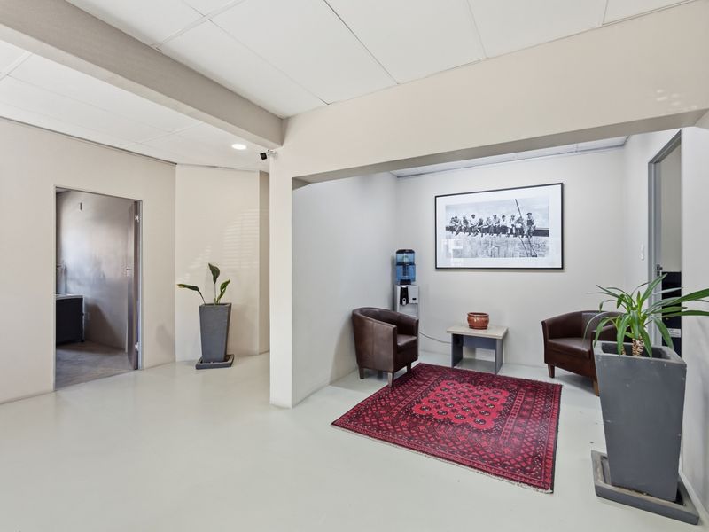 A clean, professional office reception area featuring neutral walls, suspended ceiling tiles, and durable flooring, suitable for a modern industrial workspace.