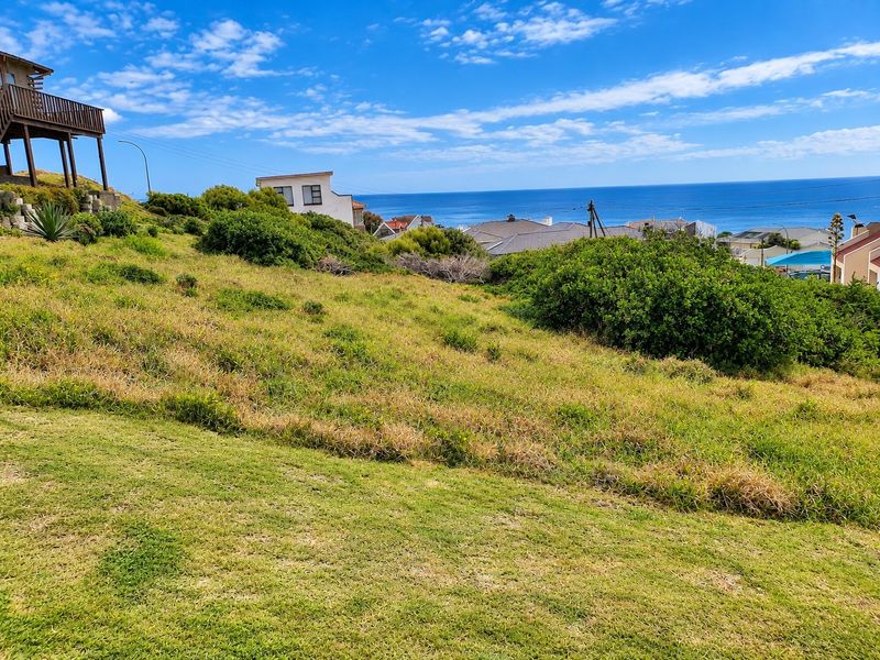 A sloped residential vacant land plot offering expansive ocean views and surrounding coastal neighborhood scenery.