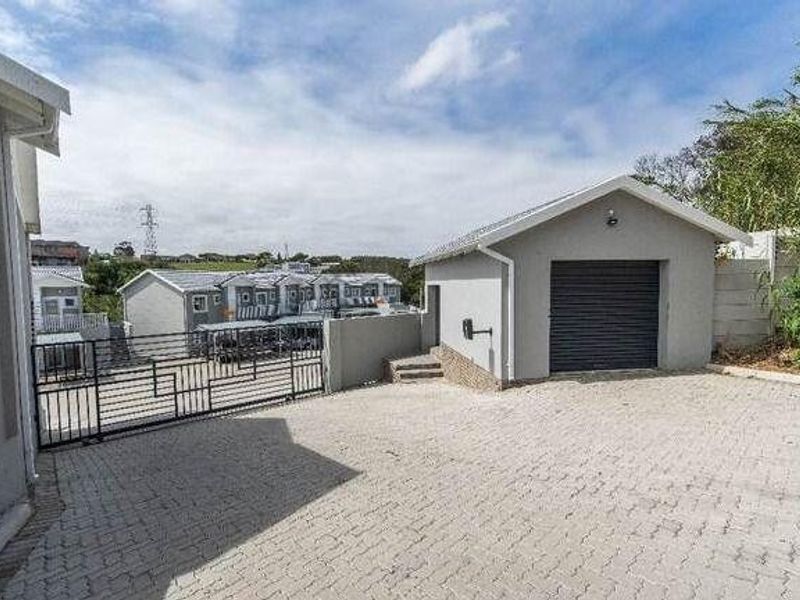 Exterior view of the property featuring a paved driveway, a single garage, and secure gated access within a residential complex.
