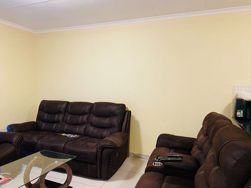 A living room area featuring tiled flooring and coved ceiling details, providing a neutral base for interior design updates.