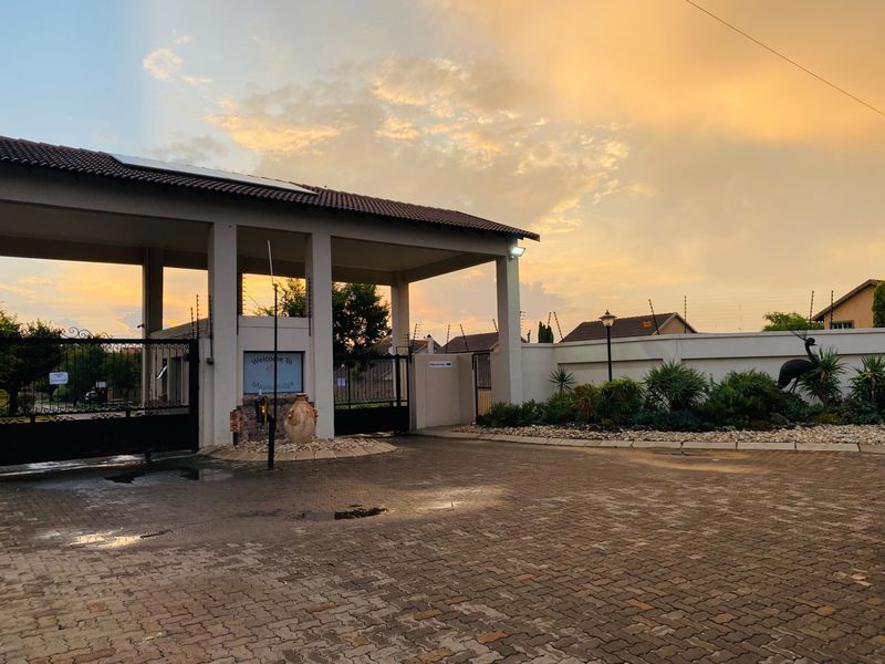 The entrance to the Maple Ridge complex features a secure gated access point with paved driveway, perimeter walling, and integrated electric fencing.