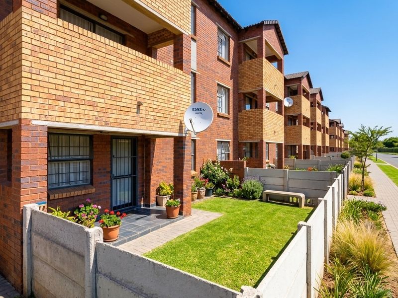 Ground floor apartment unit featuring a private garden, paved patio area, and face brick exterior with balcony access.