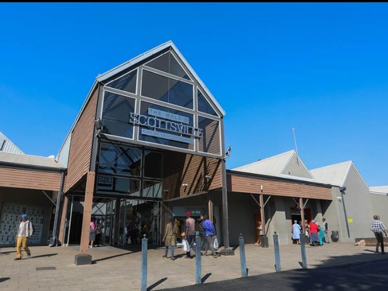 Front entrance facade of Scottsville Mall featuring modern glass and timber architectural elements with a paved pedestrian approach.