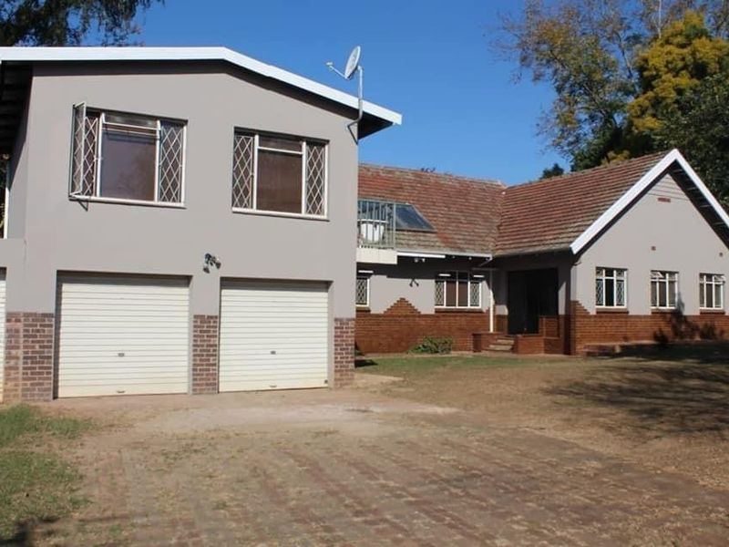 Front elevation of a two-story house featuring a double garage, tiled roof, and a combination of brick and painted exterior finishes.