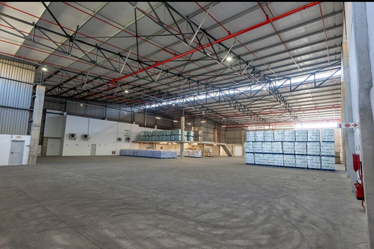 Spacious commercial warehouse featuring high-clearance steel truss roofing, polished concrete floors, integrated fire sprinkler system, and a functional mezzanine level for additional storage.