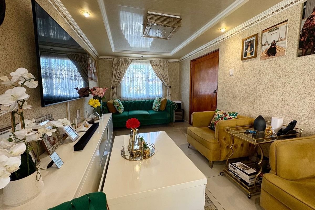 A well-maintained living room featuring textured wallpaper, decorative ceiling molding with recessed lighting, and glossy ceiling finishes.