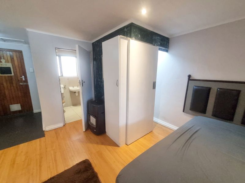Bedroom featuring laminate flooring, built-in wardrobe, and direct access to an en-suite bathroom.