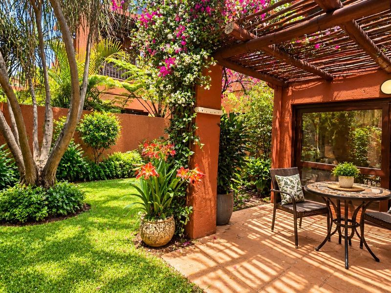 A charming covered patio area featuring a wooden pergola, tiled flooring, and direct access to a lush, well-maintained private garden.