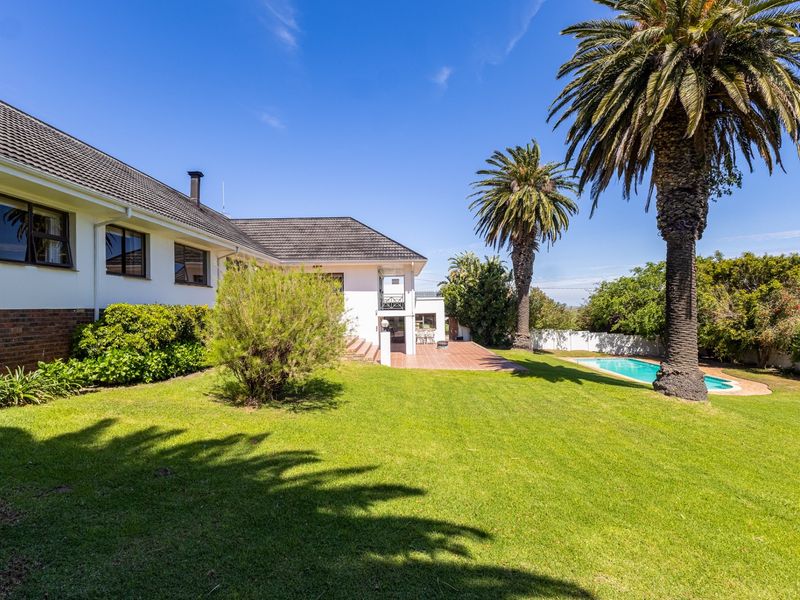 Rear view of the farm property featuring a well-maintained lawn, swimming pool, and a spacious tiled patio area.