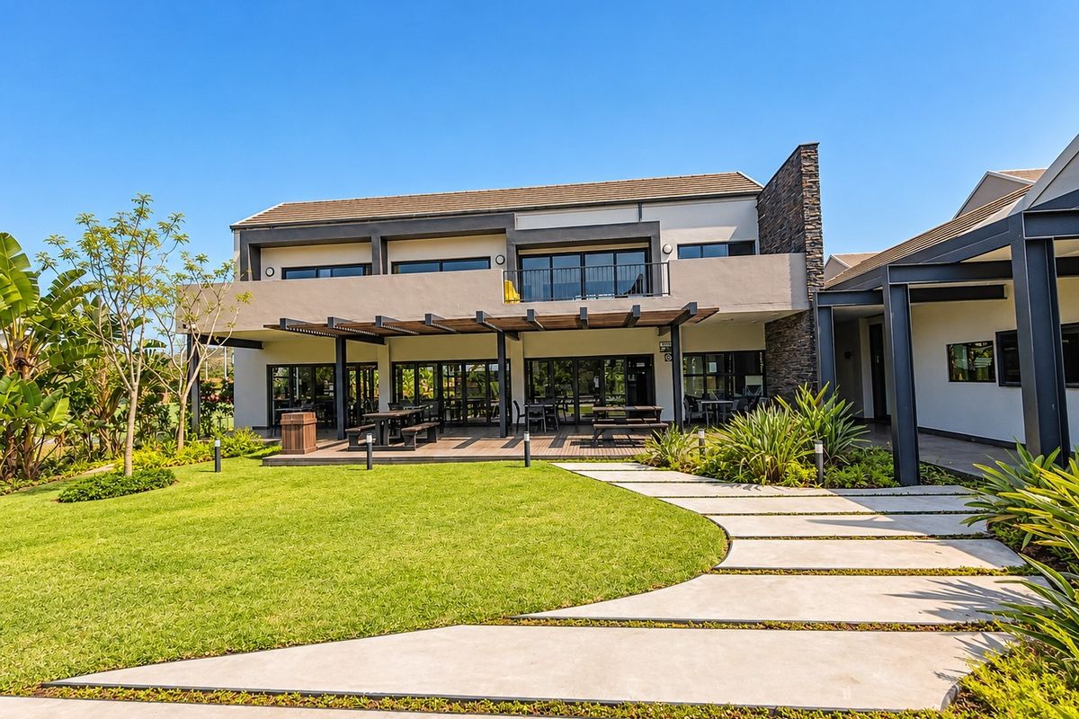 A well-maintained rear exterior view featuring a covered timber patio, landscaped garden, concrete pathway, and modern architectural finishes with stone cladding.