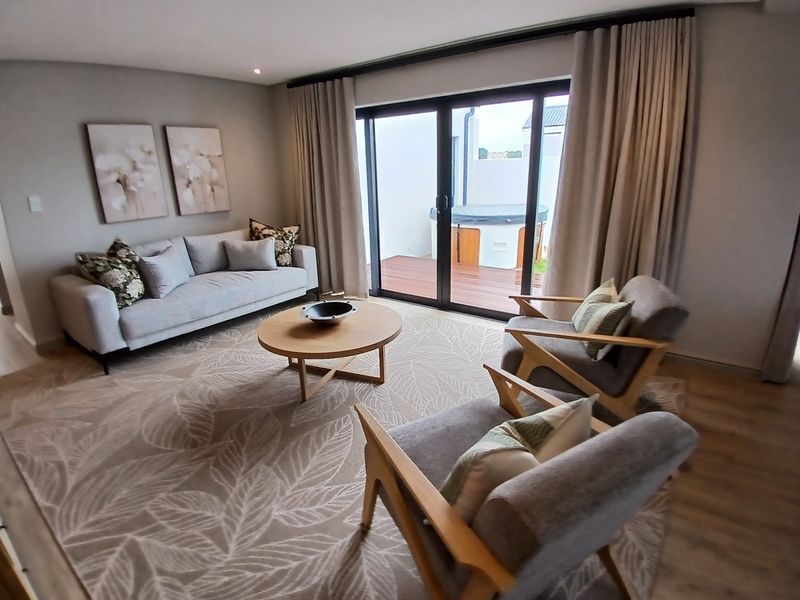 A well-appointed living room featuring large sliding glass doors that provide seamless access to an outdoor patio area.