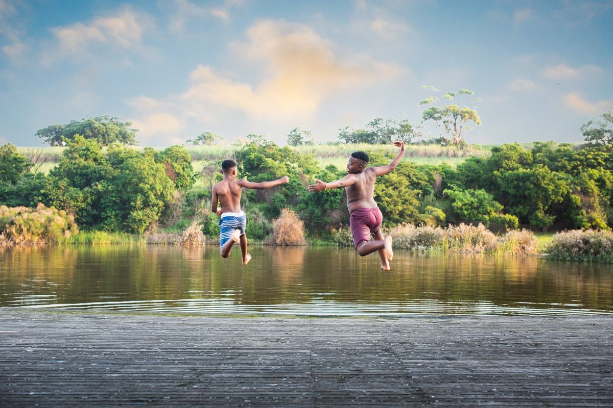 A scenic view of a natural dam featuring a wooden deck, showcasing the tranquil outdoor landscape of the small holding.