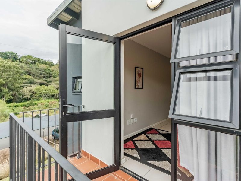 A private balcony featuring tiled flooring and a metal balustrade, offering an outdoor extension to the interior living space.