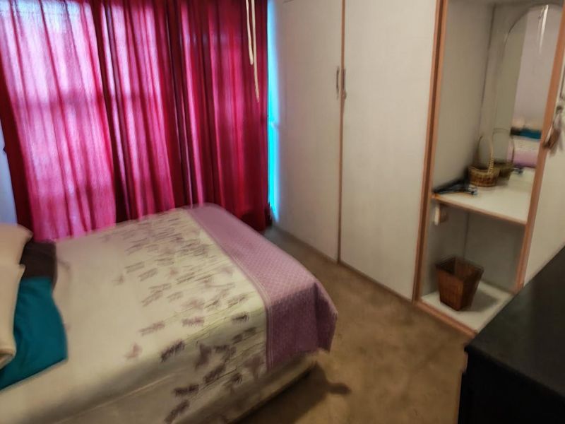 A bedroom featuring built-in cupboards and carpeted flooring, providing functional storage space.
