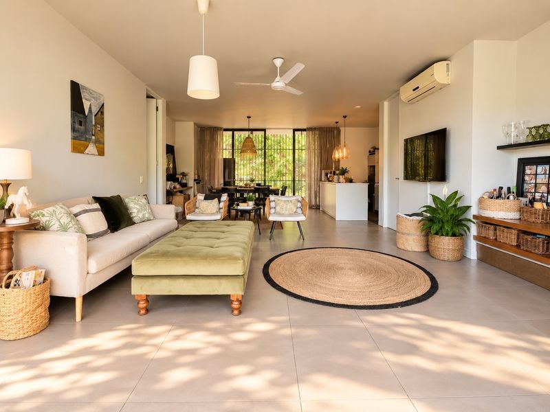 Spacious open-plan living and dining area featuring neutral tiled flooring, modern ceiling fan, split system air conditioning, and integrated shelving.
