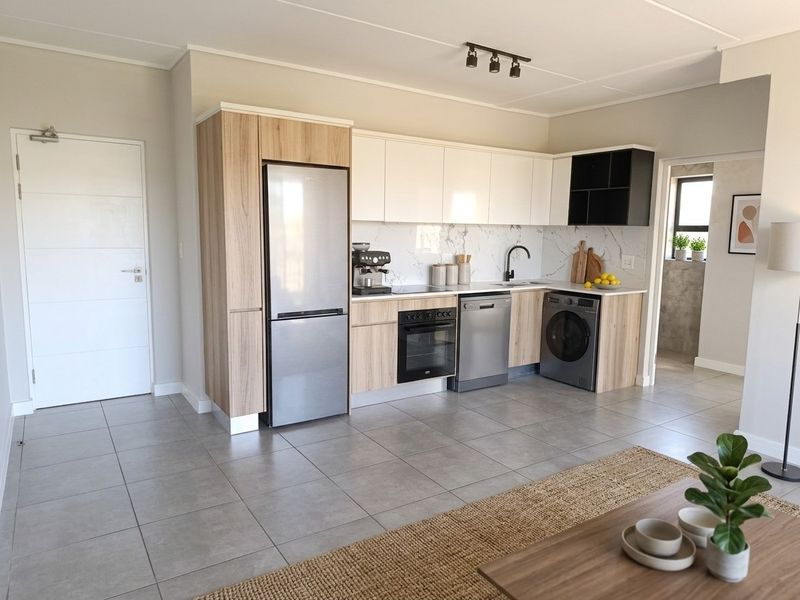 Modern open-plan kitchen featuring sleek wood-tone and white cabinetry, marble-look splashback, integrated appliances, and neutral tiled flooring.