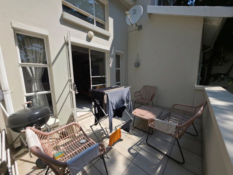 A functional balcony area featuring tiled flooring and direct access to the interior through a sliding glass door.