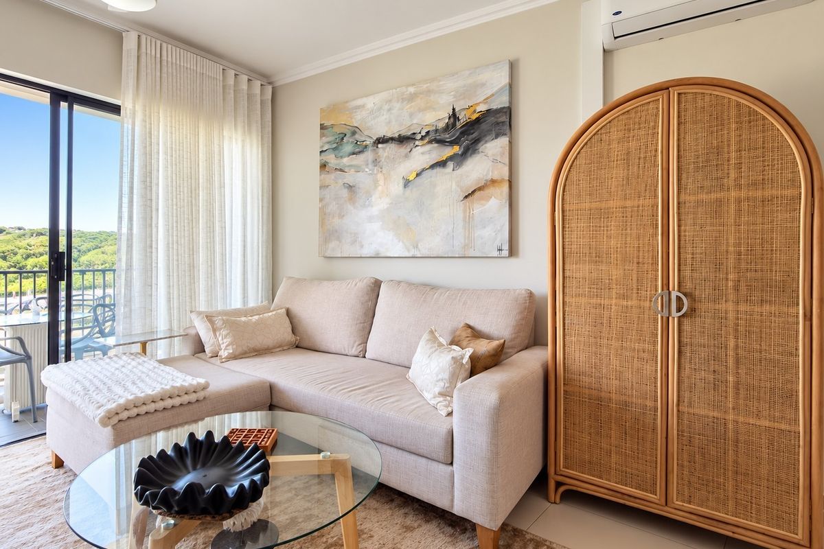A bright and well-maintained living room featuring a split-system air conditioner, ceiling fan, and large sliding glass doors leading to an outdoor balcony.