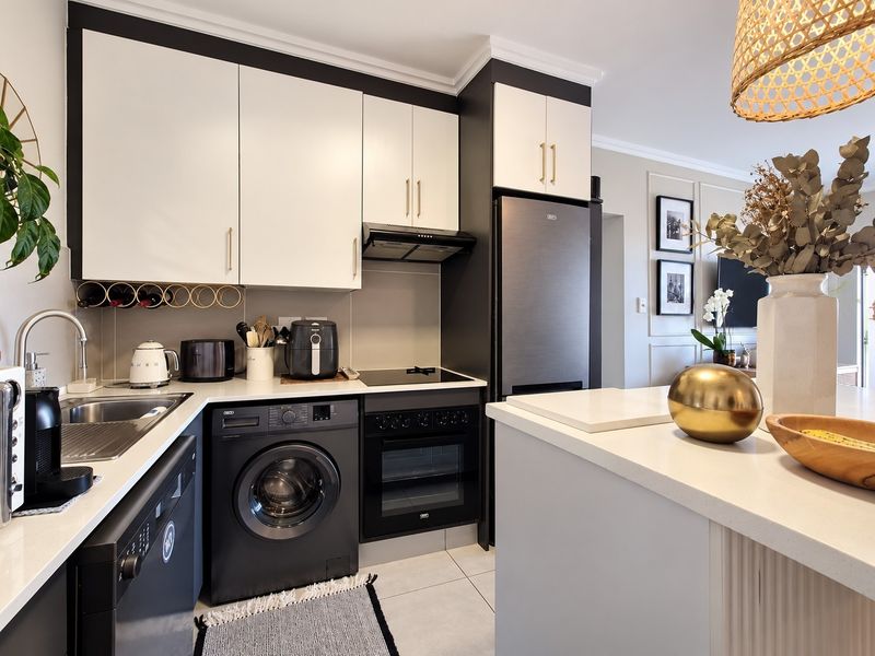 Modern open-plan kitchen featuring sleek two-tone cabinetry, quartz countertops, integrated appliances, and high-quality finishes, seamlessly flowing into the adjacent living area.