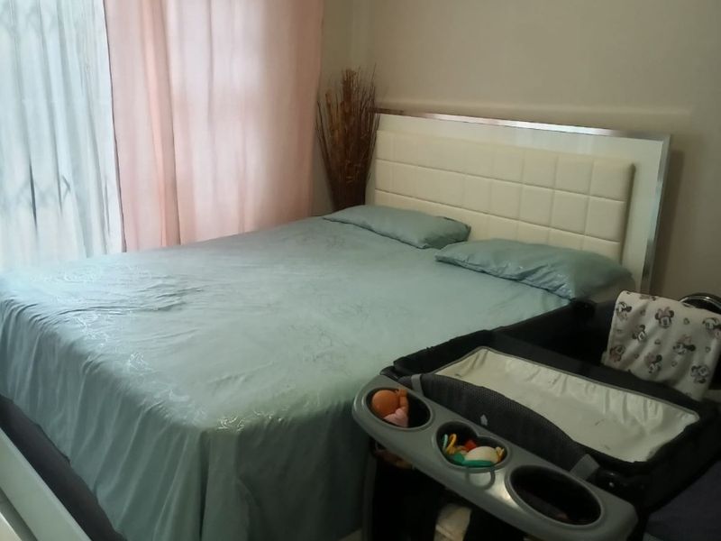 A bedroom featuring a sliding door with a security gate, providing access to the exterior.