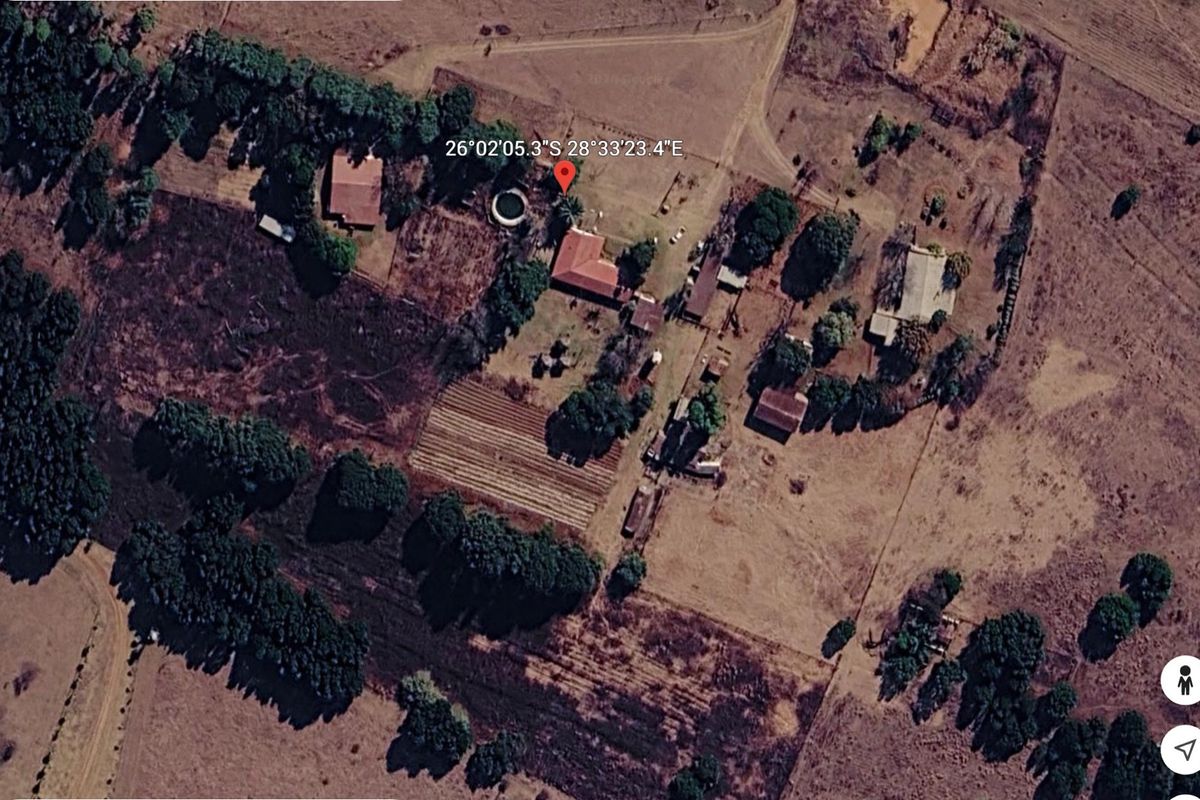 Aerial view of a farm property featuring multiple outbuildings, a swimming pool, and cultivated land areas.