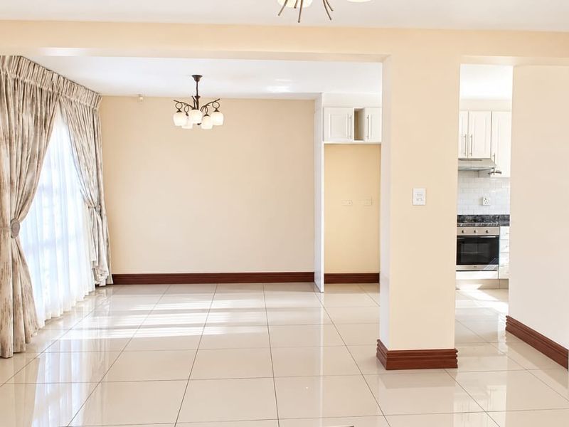 Spacious open-plan living and dining area featuring neutral tiled floors, split-system air conditioning, and a seamless transition to a functional kitchen space.