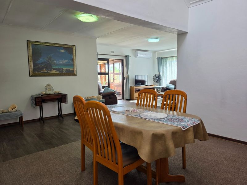 Open plan living and dining area featuring neutral walls, carpeted and wood-look flooring, and direct access to an outdoor patio through sliding glass doors.