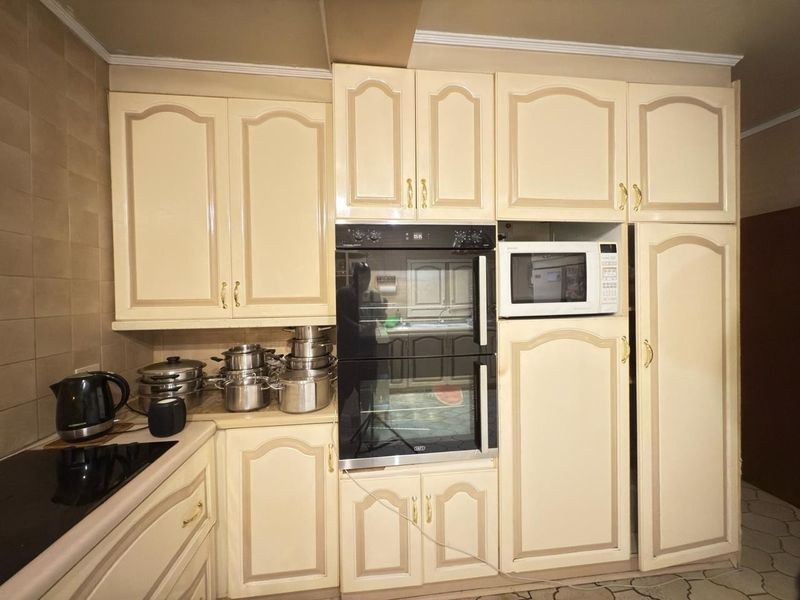 A functional kitchen featuring built-in cabinetry, a double oven, a built-in microwave, and a hob with tiled splashback.