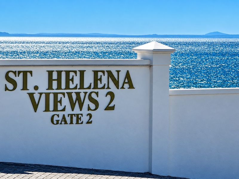 Entrance signage for St. Helena Views 2 estate, featuring a clean boundary wall with ocean views in the background.